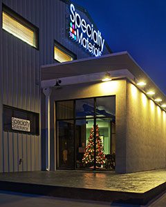 A Specialty Materials building during Christmas- there is a Christmas tree in the window
