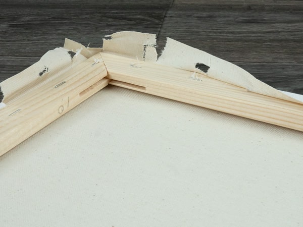 The canvas being cut or pulled away from the frame