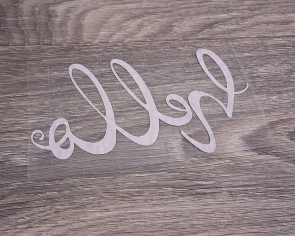 The sticker vinyl after being masked so it can be applied to the wooden round.