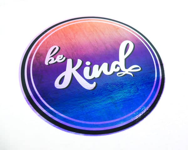 The "Be Kind" sublimation file pressed onto Blue DecoFilm® Brilliant Chameleon and then pressed on a white tshirt.