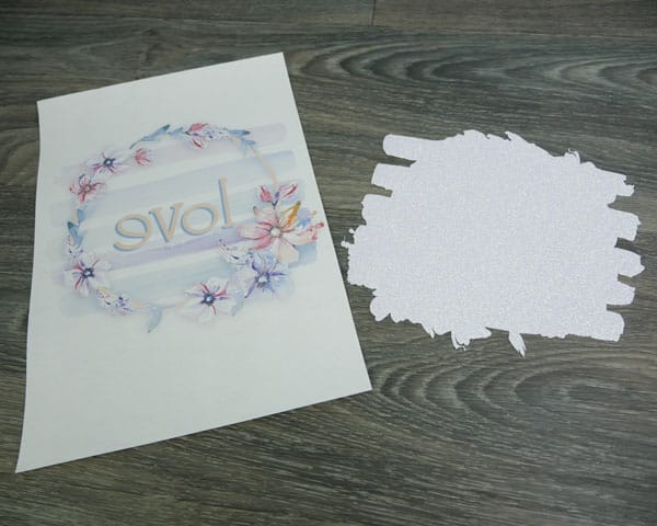 The sublimation paper printed with a sublimatable image and the cut GlitterFlex Ultra ready to be lined up